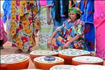 Peul woman sitting in front of calabashes